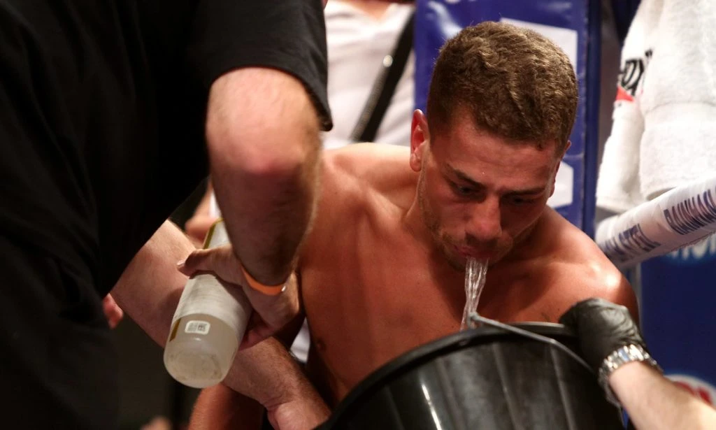 a boxer spitting in a bucket